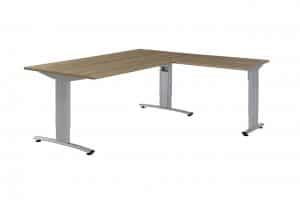 Witte achtergrond met daarvoor een bureau met hoekopstelling. Deze heeft aluminium poten en een lichthouten blad. Dit is een bureau met hoek met rechts de aanbouw.