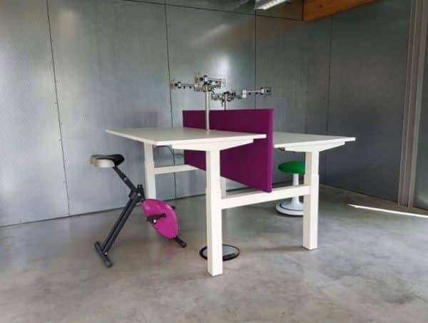 Duo zit sta bureau met wit onderstel en witte bladen, met een fuchsia akoestisch paneel in het midden.