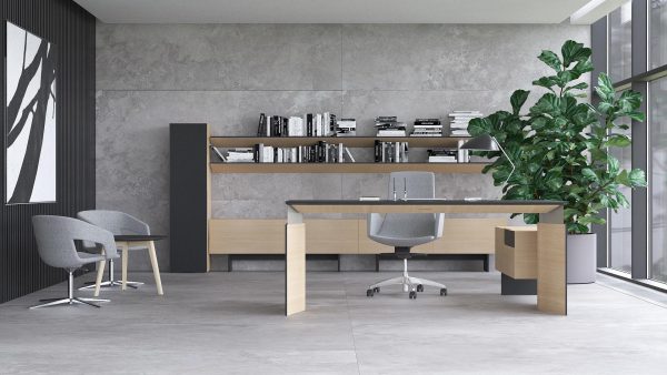 Directieruimte met betonlook. In de ruimte staat een design bureau met ronde wangen en fineerlaag.