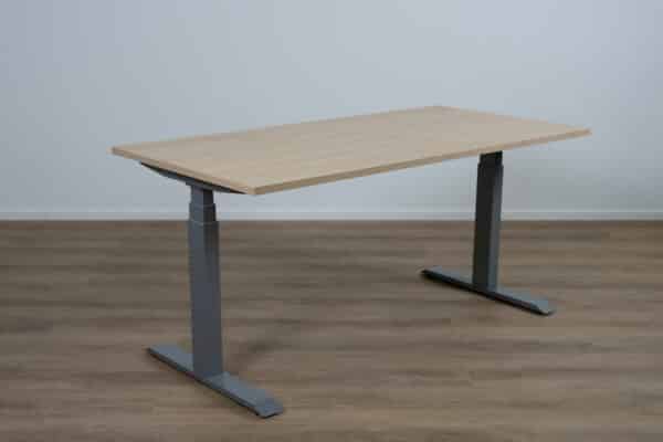 Verstelbaar bureau met een licht eiken blad en een aluminium poot.