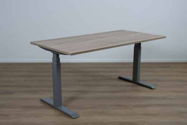 Verstelbaar bureau met een bruin blad en een aluminium poot.