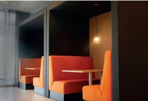 oranje treinbanken in een akoestische, open cabine. Ze staan tegenover elkaar met in het midden een bankje en daarboven een lamp. Dit is de stilte werkplek 6 personen Model Sydney.