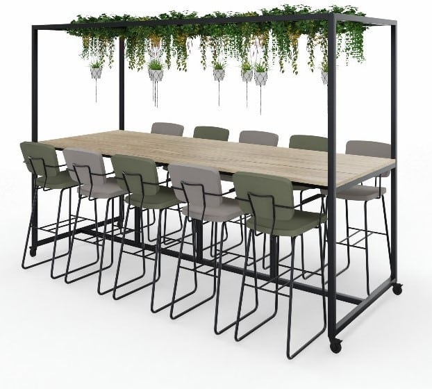 Witte achtergrond met daarop een verrijdbare, hoge vergadertafel. Deze heeft een metalen ombouw waarin planten hangen. Aan de tafel staan barkrukken in het grijs.