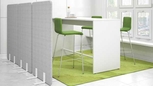 Grijze akoestische panelen staan om een zithoek heen in een kantoor.