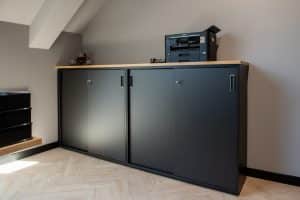 Zwarte schuifdeurkast met een licht houten topblad.