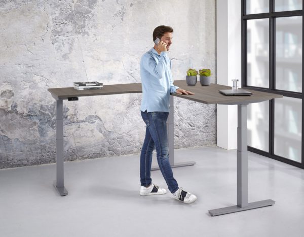 Elektrisch verstelbaar hoekbureau met een aluminium poot en een donker eiken blad.