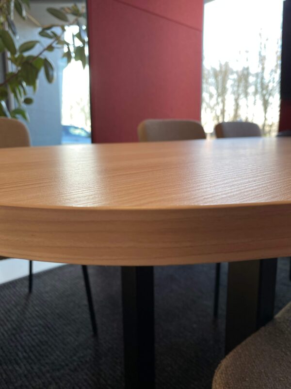 Houten tafel in de rode vergadercabine.