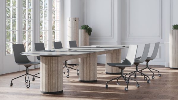 Klassieke vergaderruimte, met links een wand met ramen. In de ruimte staat een grote vergadertafel ovaal. Eromheen staan acht vergaderstoelen. De poten zijn kolommen van PET-vilt.