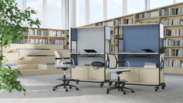 We zien twee roomdividers in een kantoorruimte. Ze doen hier dienst als werkruimte. Achter de roomdividers staan namelijk twee bureaustoelen en in de dividers zien we een kastenwandje en een bureaublad.