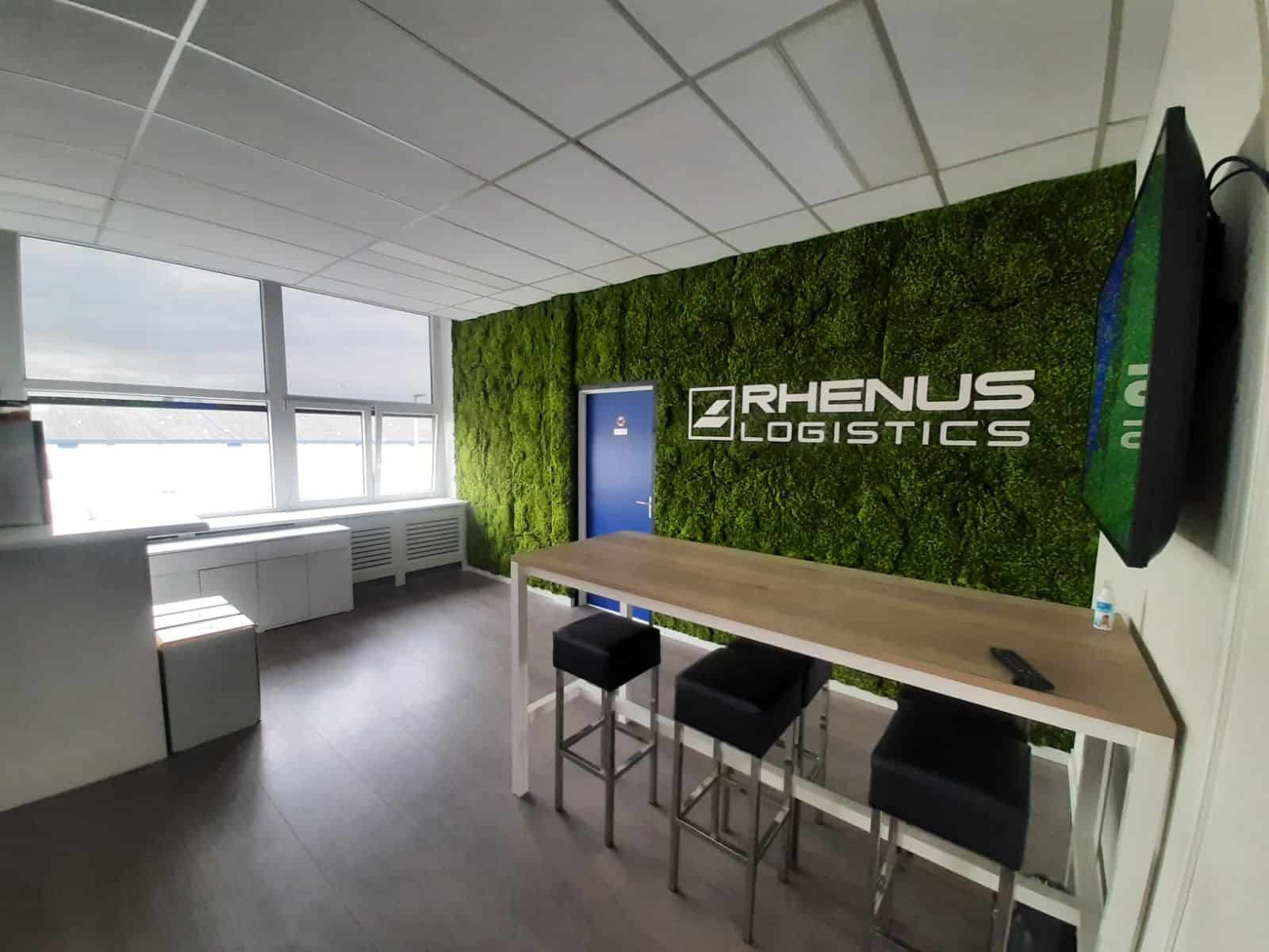 Moswand in een kantine, met daarop het logo "Rhenus Logistics" in het wit.