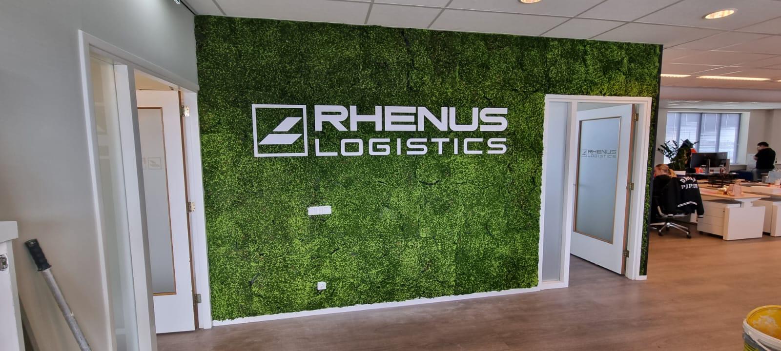 Grote moswand met een deuropening erin. Op de mos wand zien we het logo Rhenus Logistics in het wit.