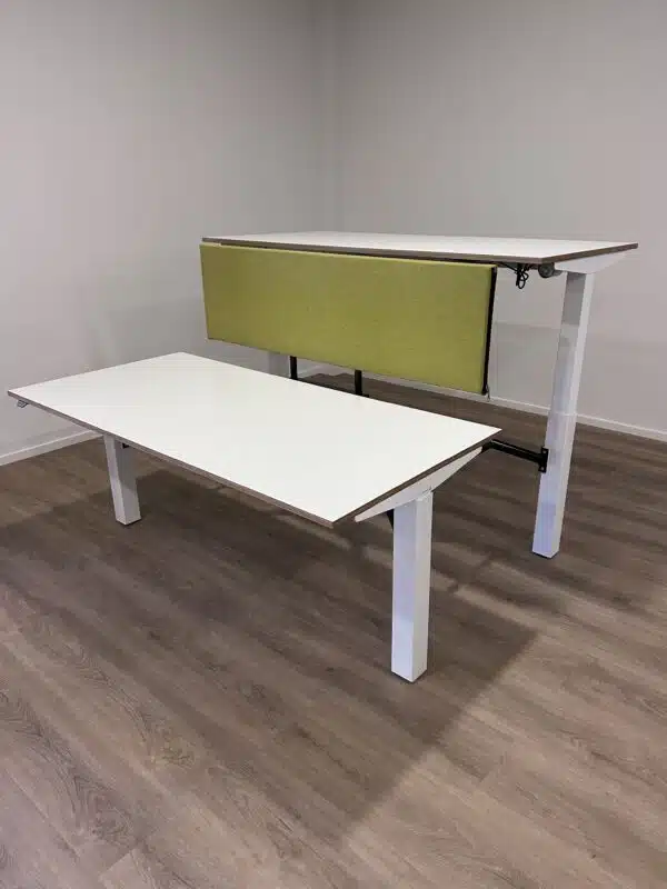 Elektrisch verstelbaar bureau met witte poten en bladen en een groen akoestisch scherm.