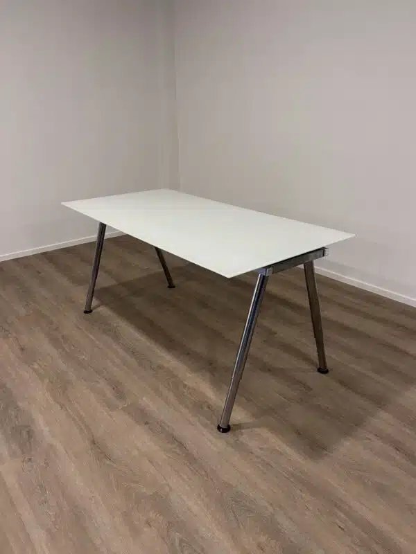Gebruikt bureau met een wit blad en een chromen V-poot onderstel.