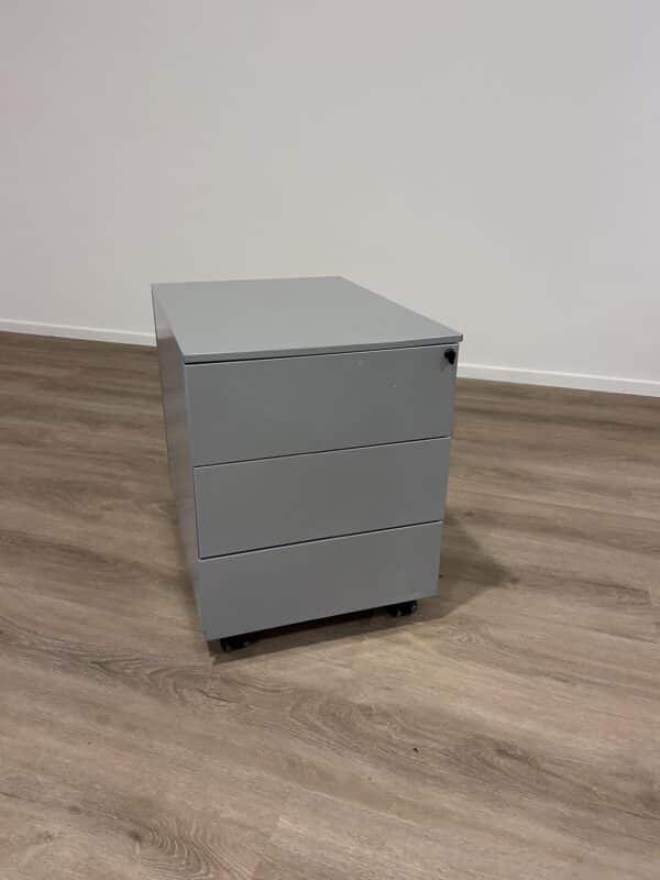 Gebruikt grijs ladeblok met drie laden en een slot bovenin.