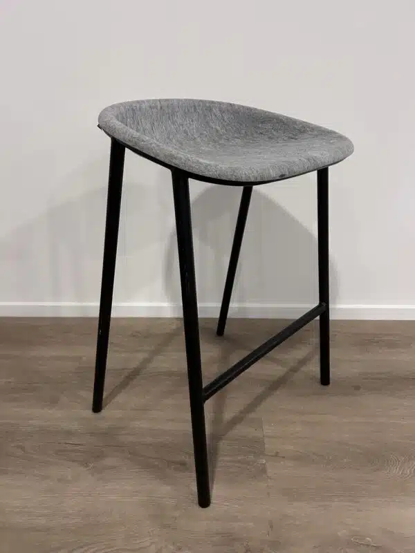 Barkruk met zwart metalen frame en lichtgrijze vilten zitting.