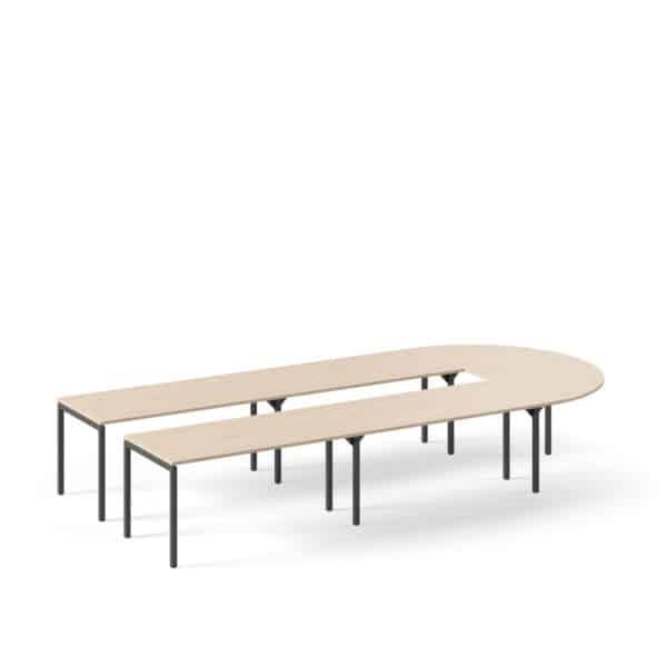 Grote U-vorm vergadertafel met een licht houten blad en zwarte rechte poten eronder.
