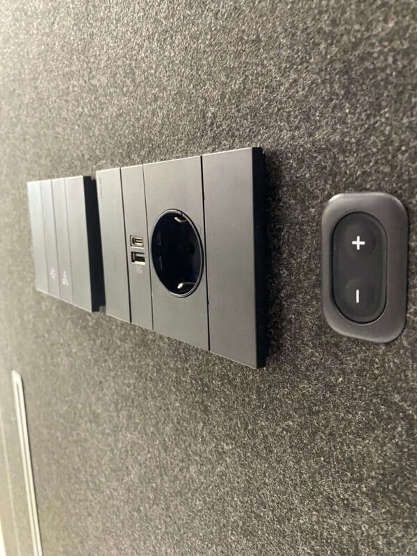 Stopcontact en USB-C oplader in akoestische werkplek.