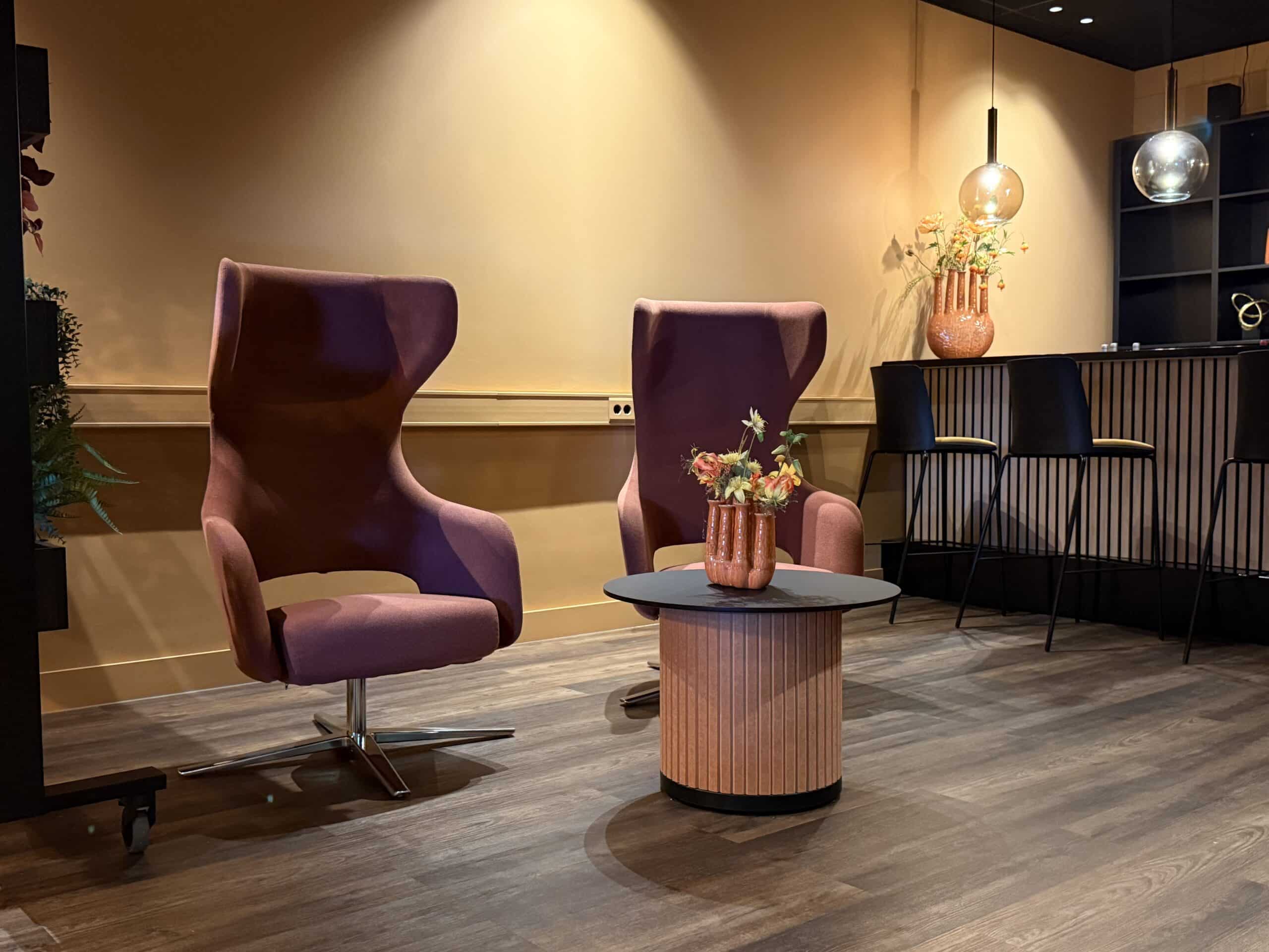 Rode akoestische loungestoelen in zithoek.