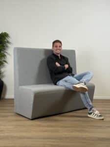 Blauwgrijze wandbank met man erop.