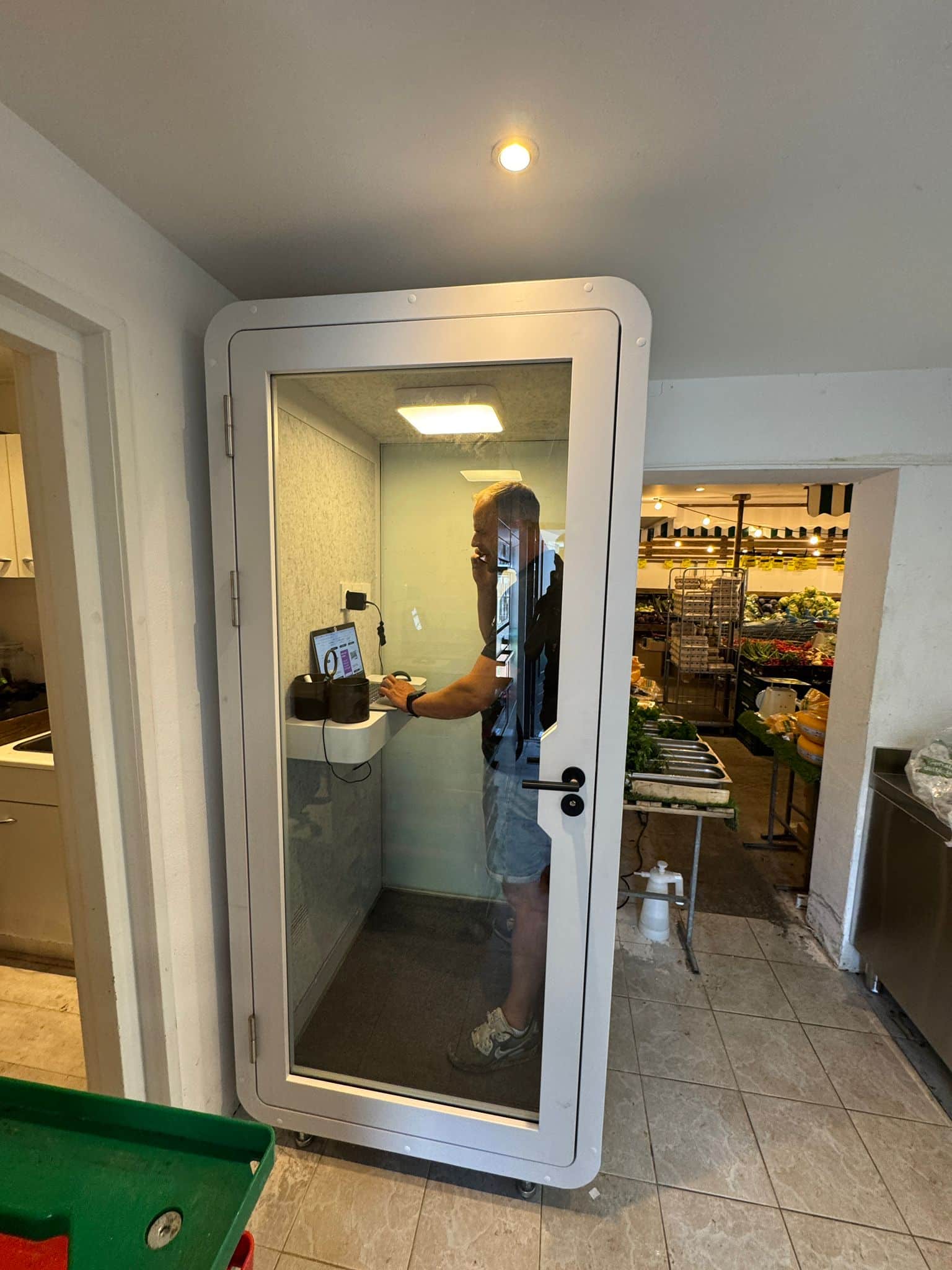 Man in tweedehands belcel in een groentewinkel.