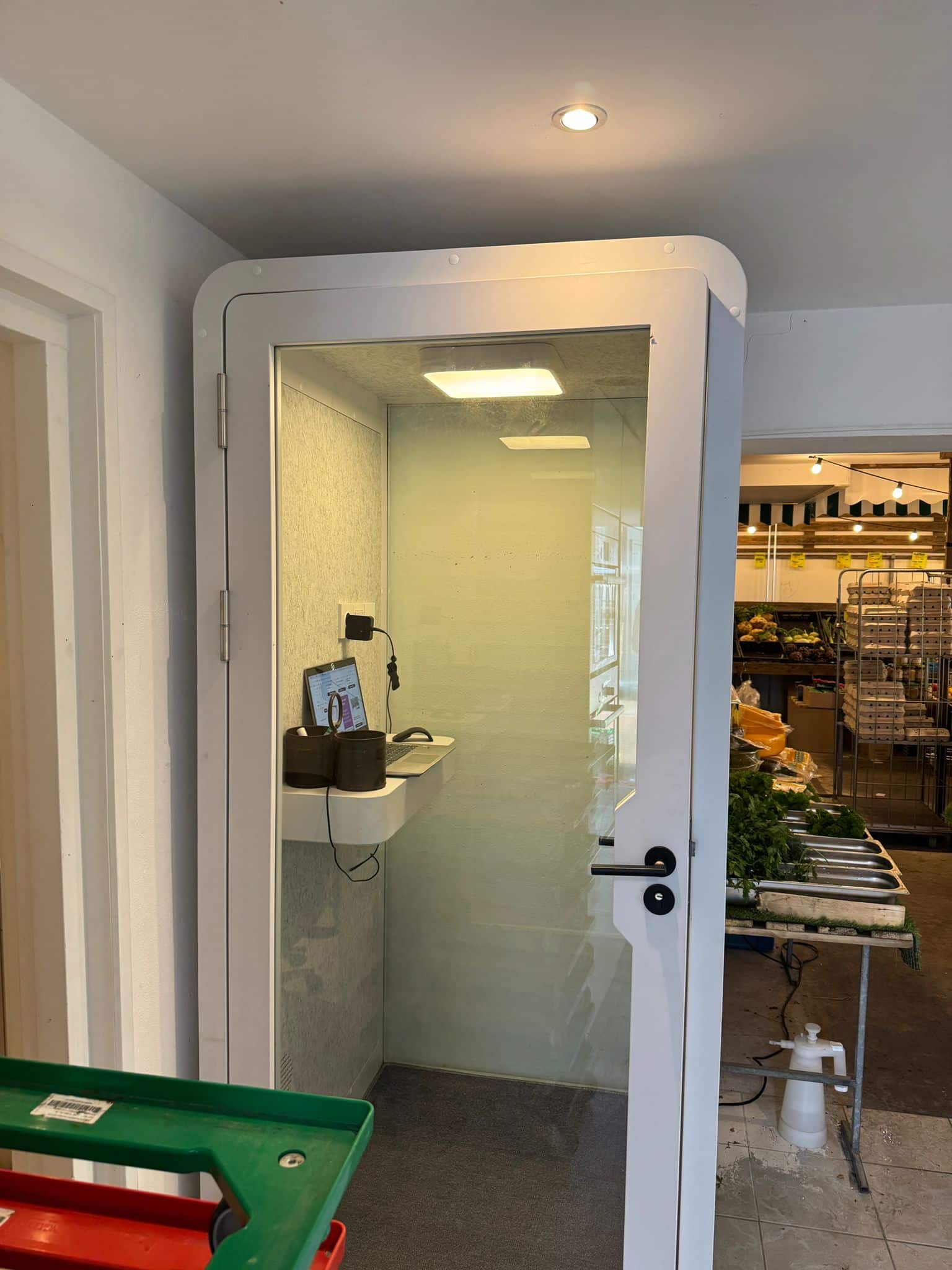 Wit belhokje met groengrijze binnenkant en een tafeltje erin.