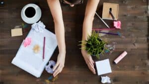 Twee handen ruimen een bureau op voor clean desk policy.