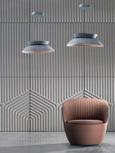 Lichtgrijze Bowl lamp van Feltouch boven een stoel.