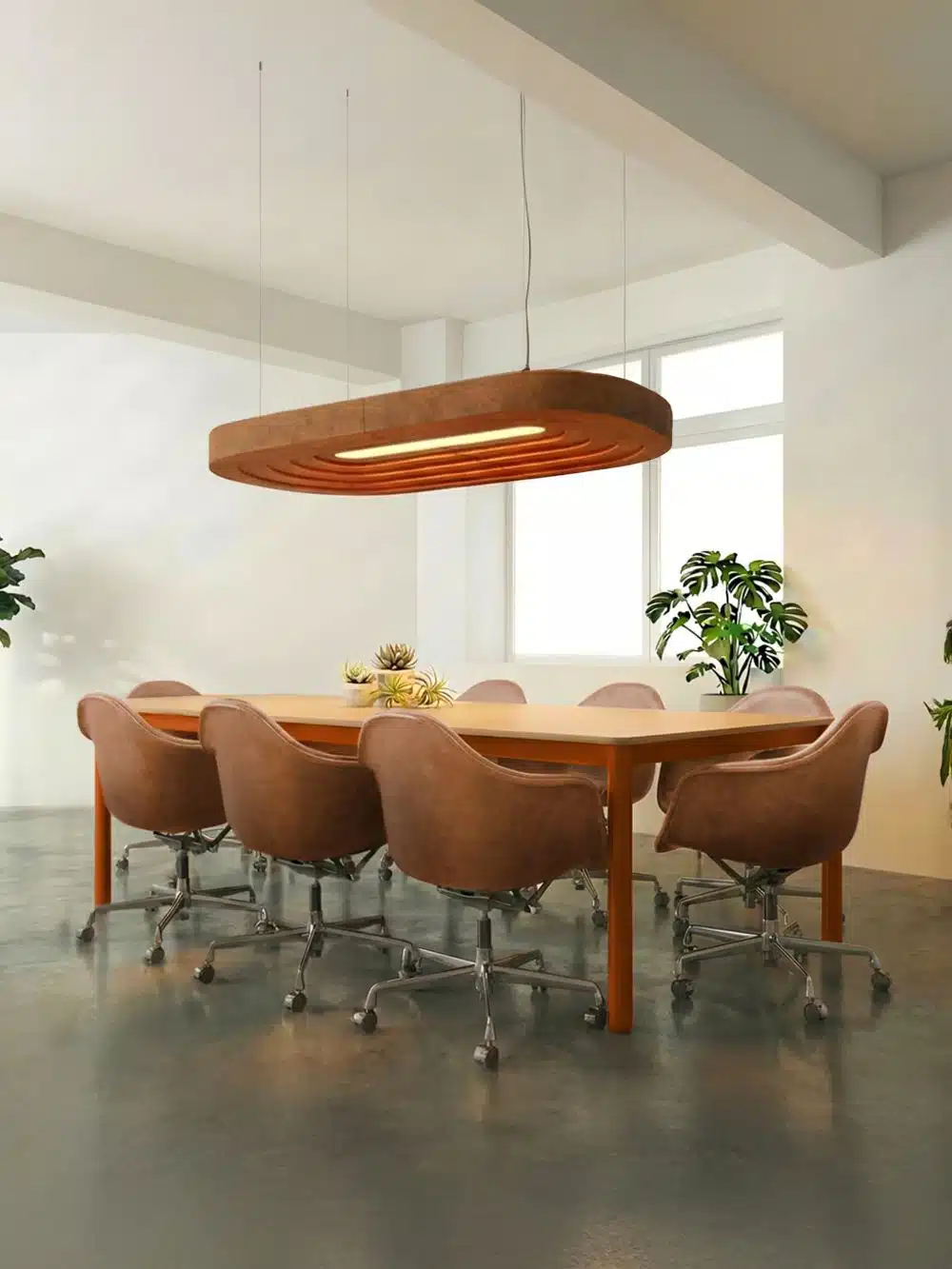 Oranje stoelen rond een grote vergadertafel met daarboven een elipsvorm akoestische hanglamp