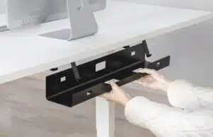 twee handen die zwarte kabelgoot aan tafel maken