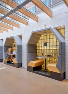 Akoestische treincabine in het grijs met gele banken.